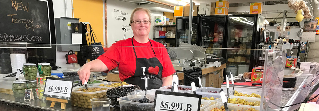 Christine owner of Romano's Cheese stands by her Olive bar