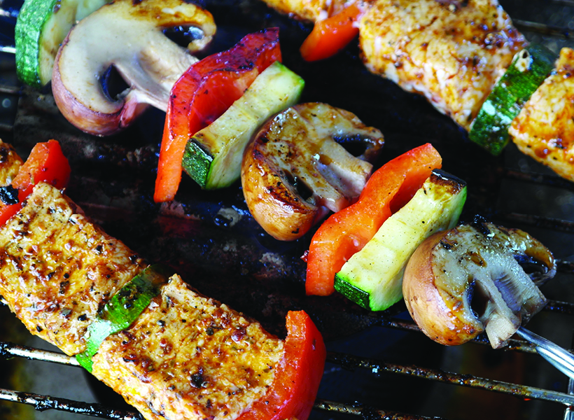 Vegetables cooking on the BBQ, drizzled in sauce and toasting