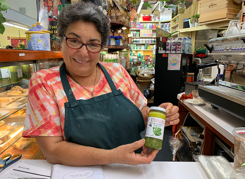 Maria from Ercilia’s Fine Foods holding up her famous Cilantro Sensational Sauce
